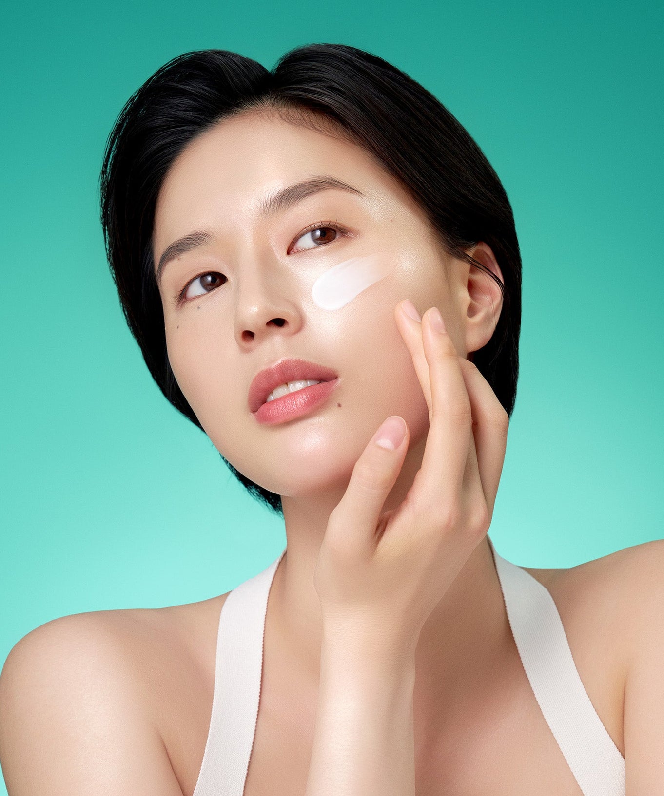 Woman applying PURITO Mighty Bamboo Panthenol Cream 100ml on face, showcasing skincare routine.