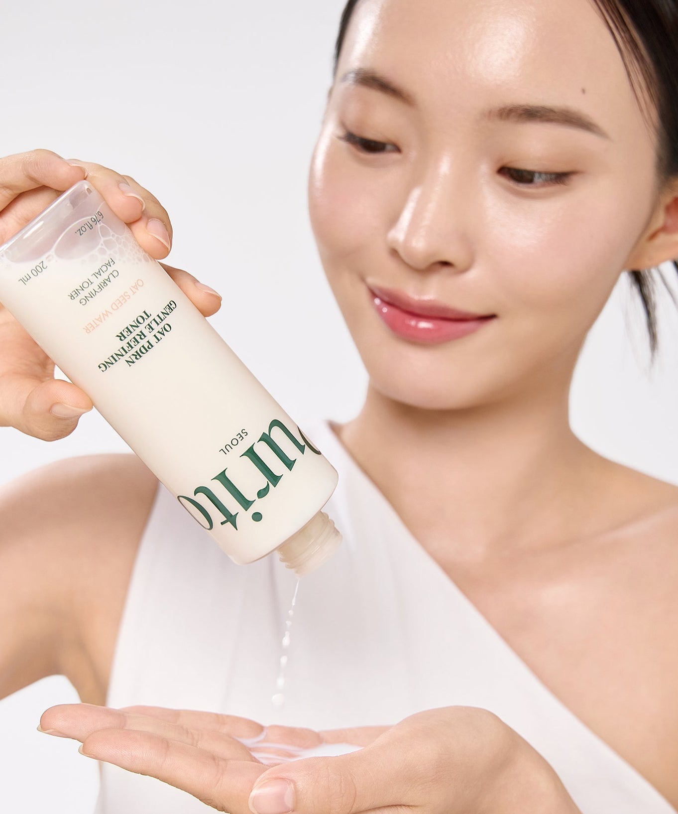 Woman using PURITO Oat PDRN Gentle Refining Toner 200ml skincare product