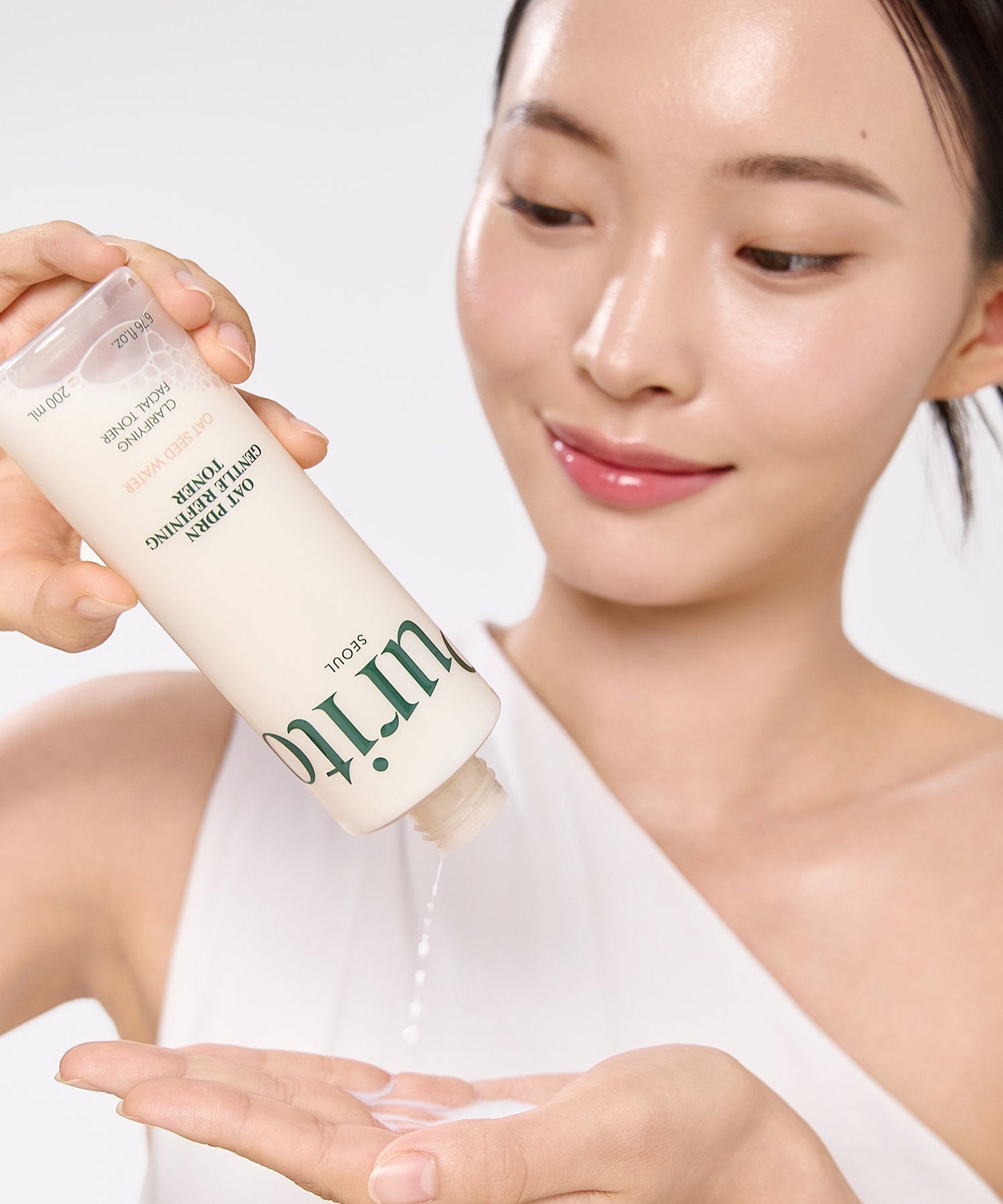 Woman using PURITO Oat PDRN Gentle Refining Toner 200ml skincare product