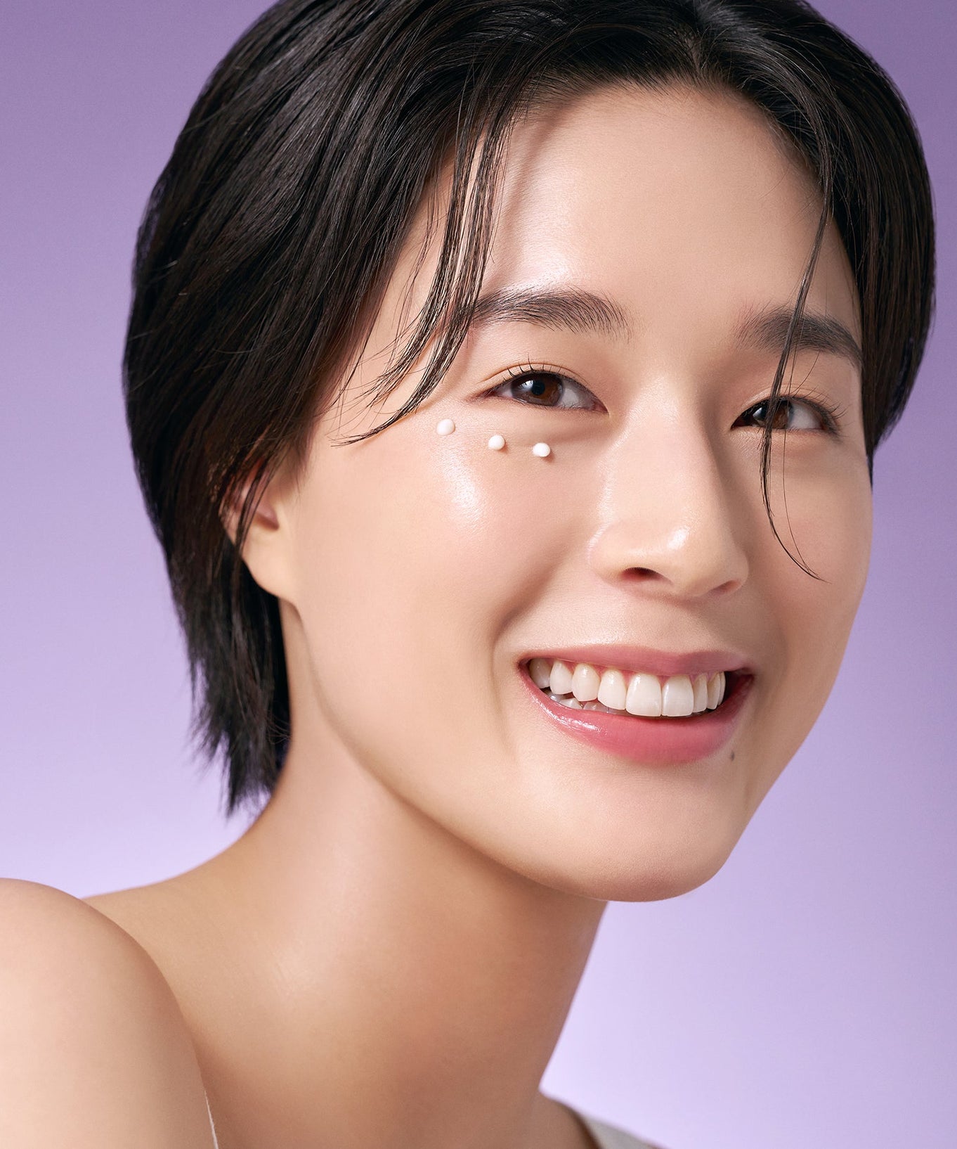 Woman applying PURITO Timeless Bloom Retinol Spot Cream 30ml on her face with a smile, emphasizing skincare benefits.