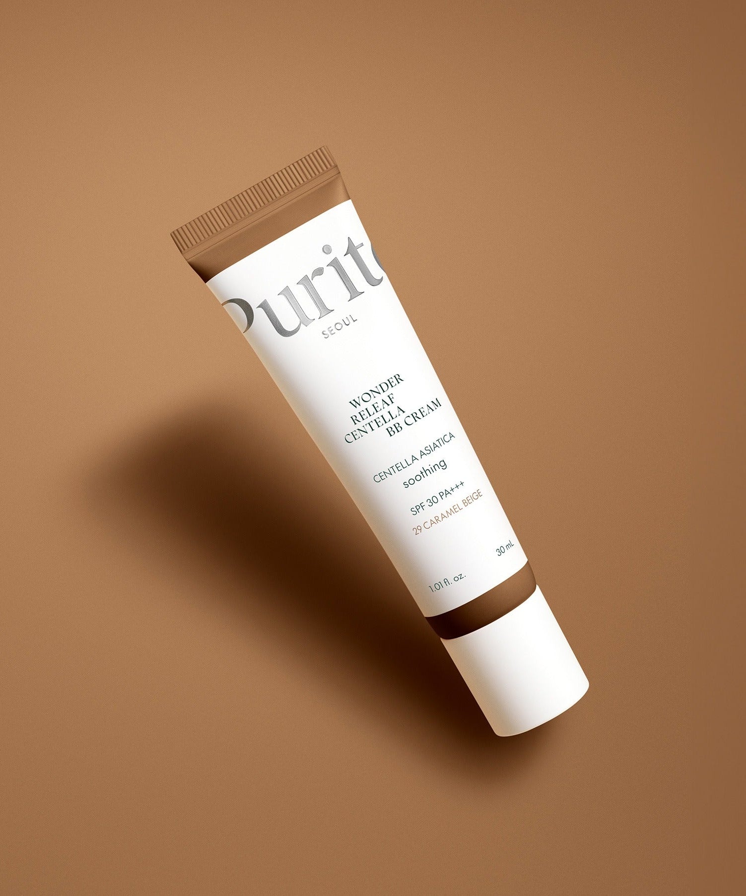 PURITO Wonder Releaf Centella BB Cream 30mml in a brown tube against a soft brown background.