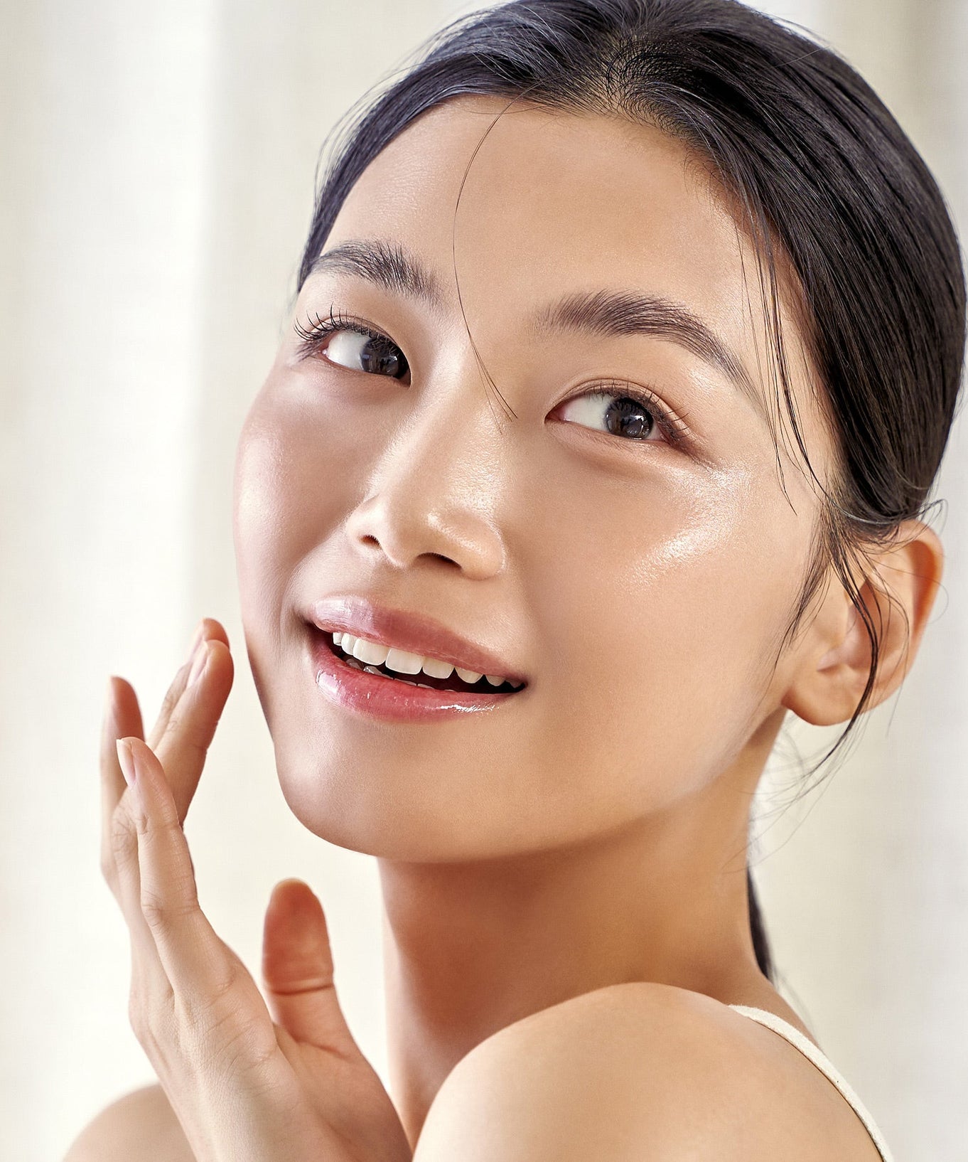 Woman with glowing skin using PURITO Wonder Relief Centella Daily Sun Lotion SPF50+PA++++