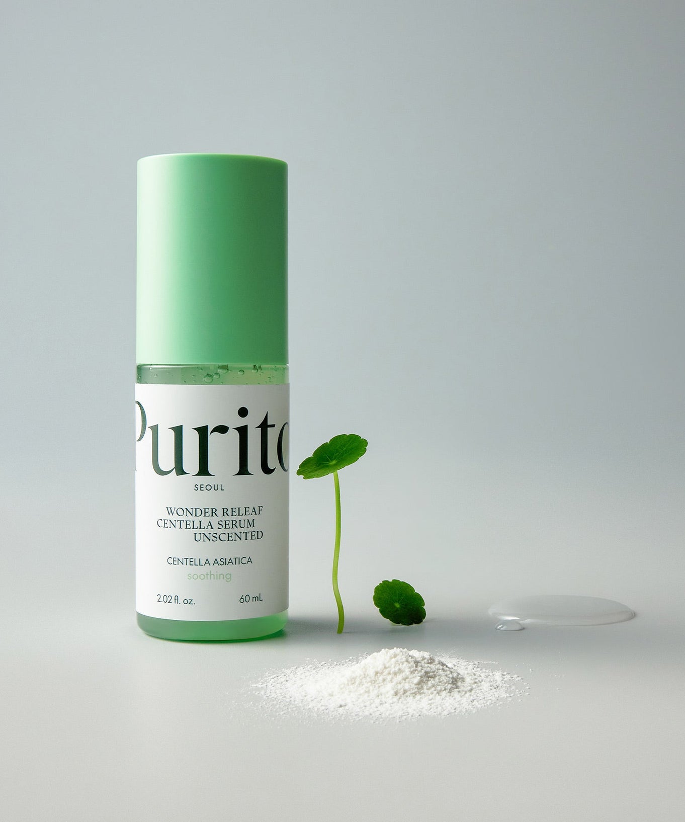 PURITO Wonder Relief Centella Serum Unscented 60ml bottle with green cap, next to centella asiatica leaf and powder.
