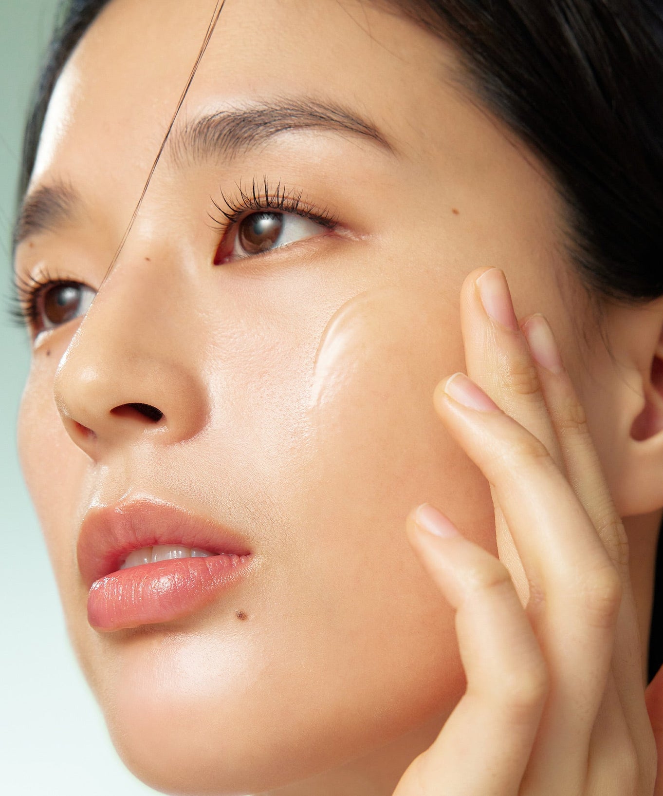Close-up of person applying PURITO Wonder Relief Centella Serum Unscented 60ml on skin.