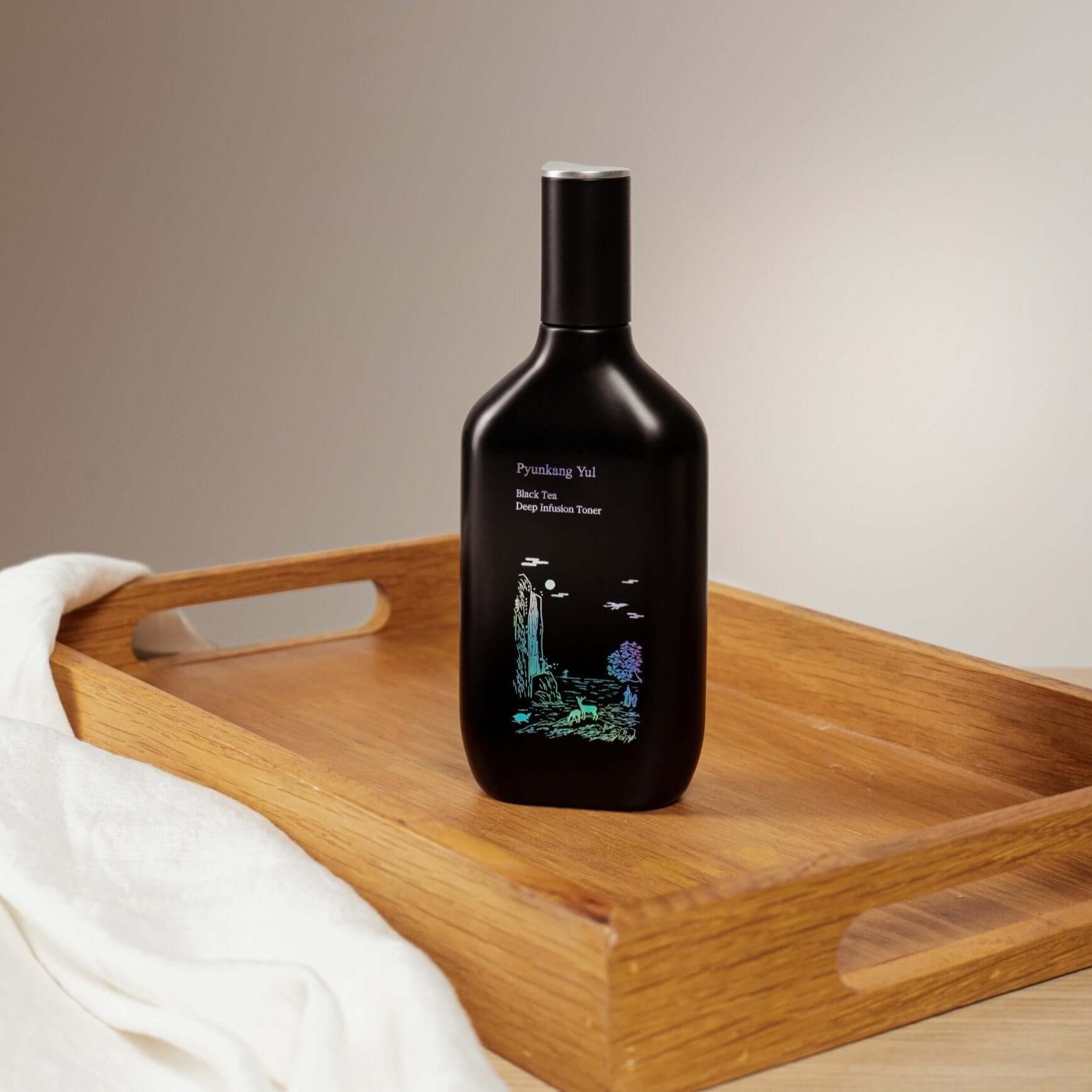 PYUNKANG YUL Black Tea Deep Infushion Toner 130ml bottle on a wooden tray