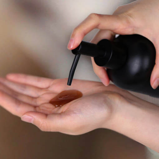 Dispensing PYUNKANG YUL Black Tea Oral Hair Loos Relief Shampoo 500ml onto hand