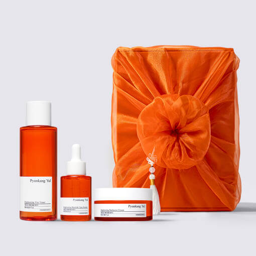 PYUNKANG YUL Brightening Bojagi Gift Set with orange packaging, includes toner, serum, and cream for skincare rituals.