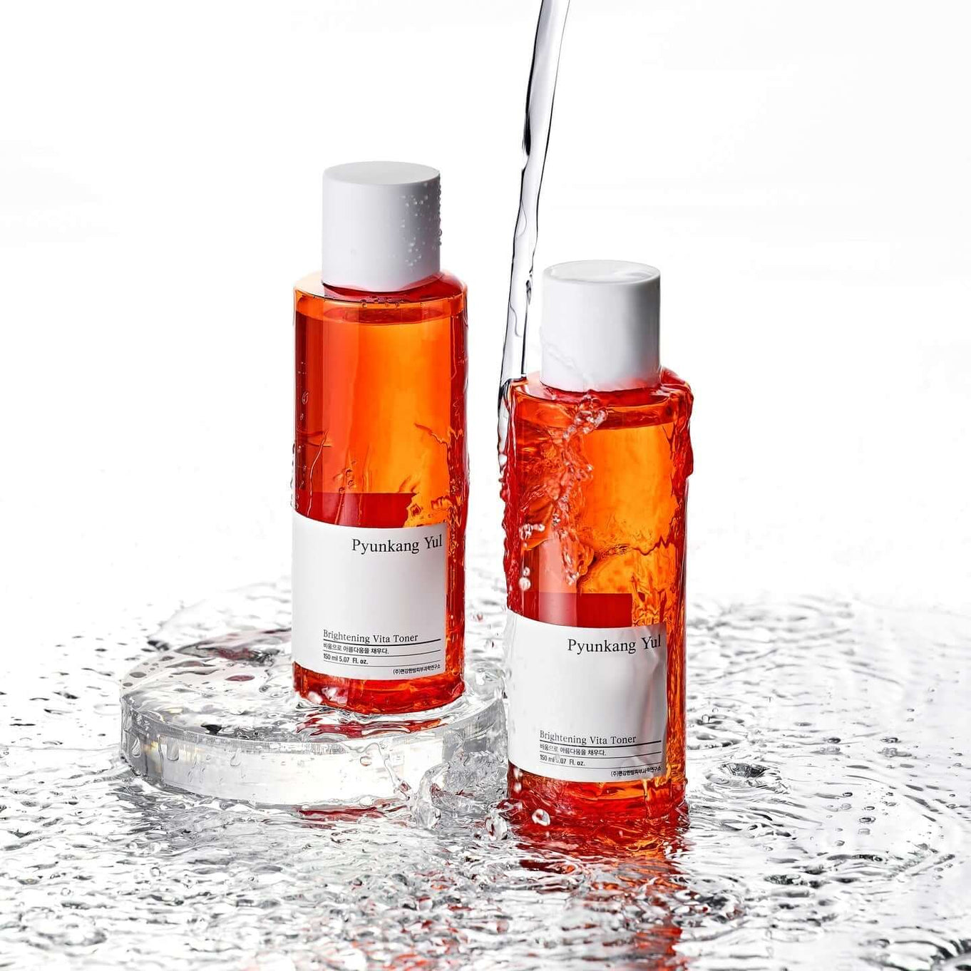 Two bottles of PYUNKANG YUL Brightening Vita Toner 150ml with water splashes.