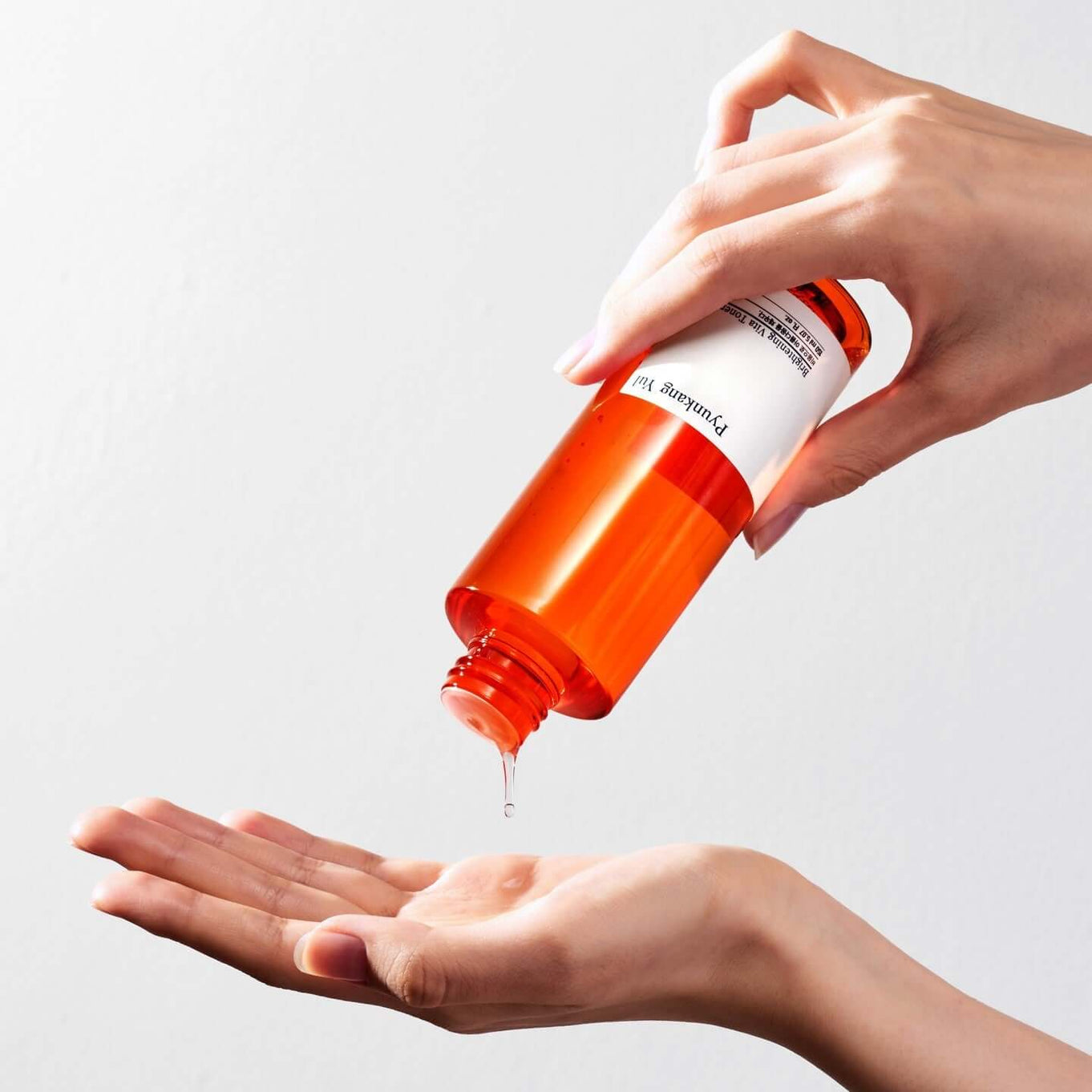 Pouring PYUNKANG YUL Brightening Vita Toner 150ml onto hand for skincare routine.