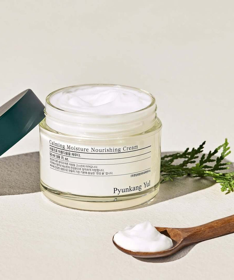 PYUNKANG YUL Calming Moisture Nourishing Cream 50ml jar with cream and a wooden spoon beside it.