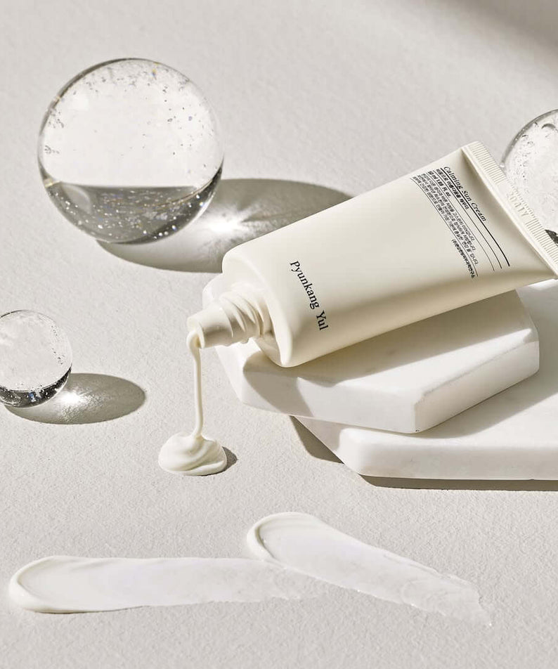 PYUNKANG YUL Calming Sun Cream SPF+PA++++ 50ml displayed with elegant product styling on a textured surface.
