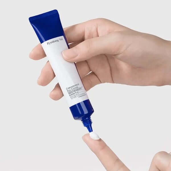 Person applying PYUNKANG YUL Intensive Care Eye Cream 25ml to fingertip.