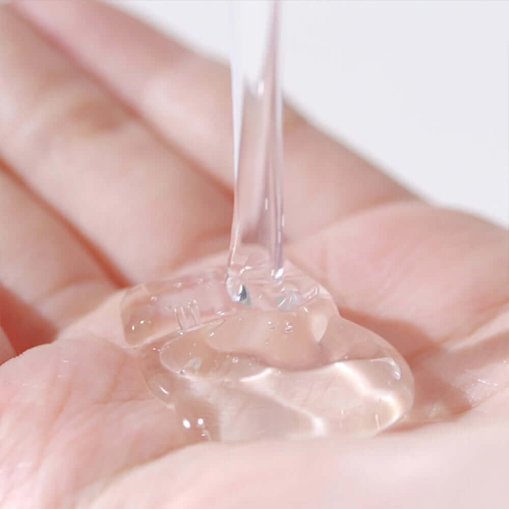 Clear gel texture of PYUNKANG YUL Low pH Scalp Shampoo 500ml in hand