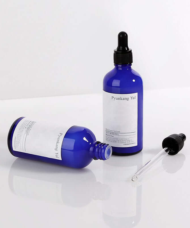 Blue bottles of PYUNKANG YUL Moisture Serum 100ml with droppers on white background