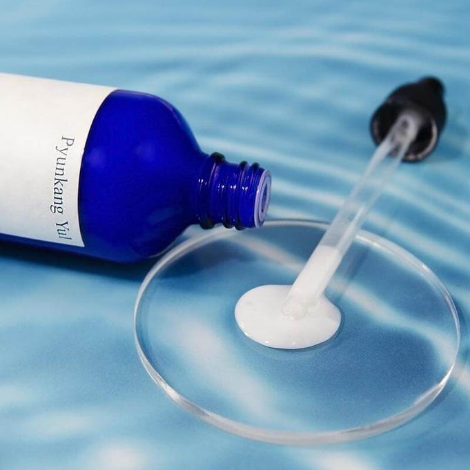 PYUNKANG YUL Moisture Serum 100ml bottle with dropper on blue background