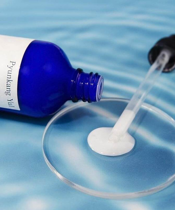 PYUNKANG YUL Moisture Serum 100ml bottle with dropper on blue background