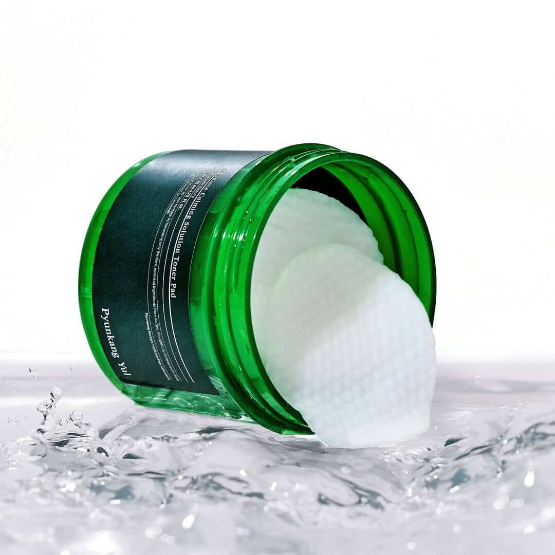 PYUNKANG YUL Ultimate Soothing Solution Toner Pads 70 sheets 140ml in a green jar on a wet surface.