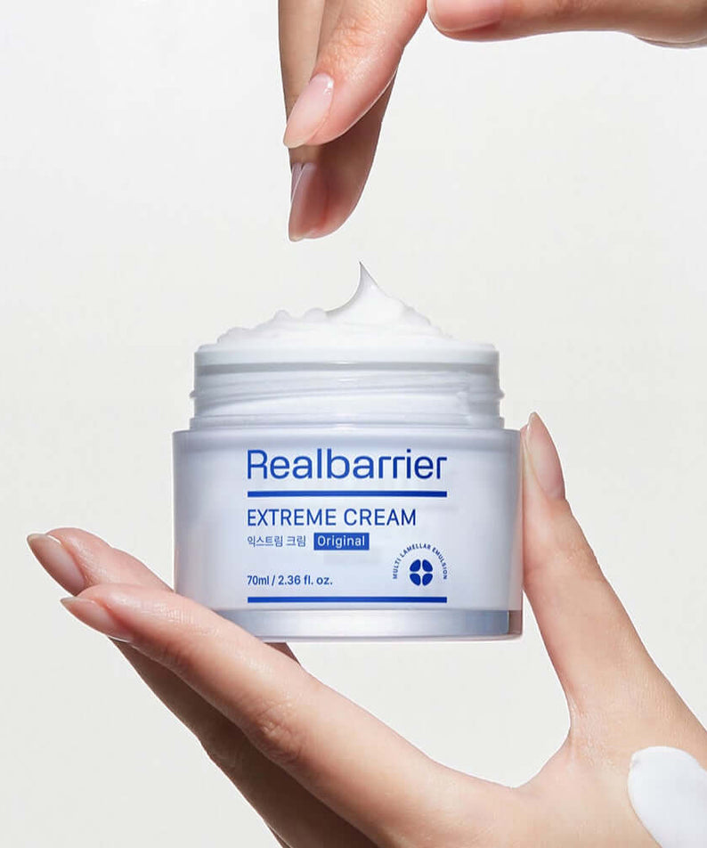 Hand applying REAL BARRIER Extreme Cream 50ml for intense skin moisturization.