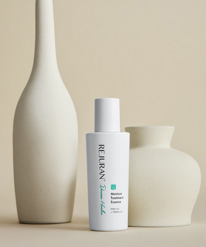 REJURAN Derma Healer Moisture Treatment Essence 70g bottle with decorative vases in a minimalist setting