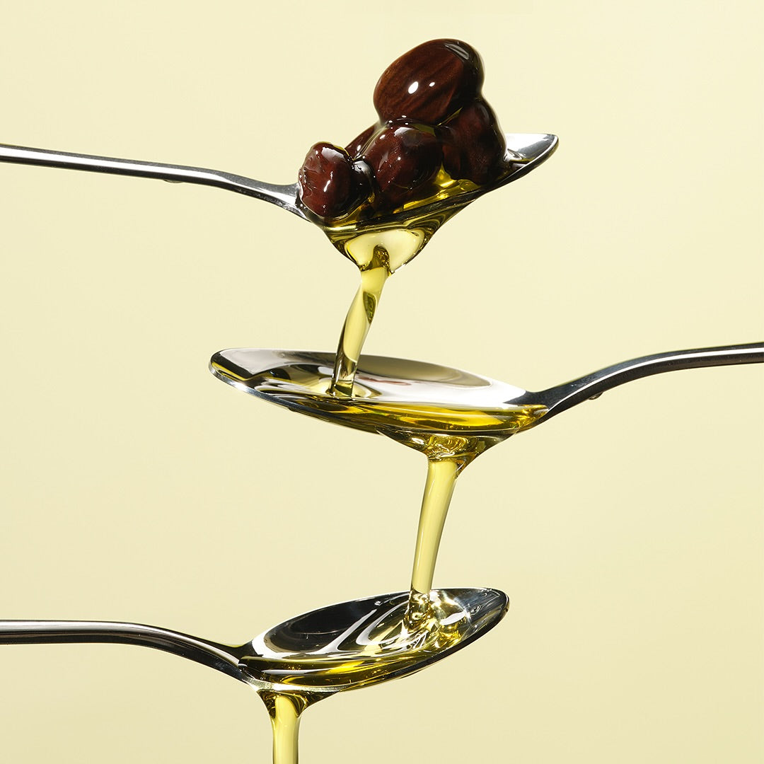 RETURNITY Organic Jojoba Oil 100% 50ml flowing from spoon, showcasing texture and quality
