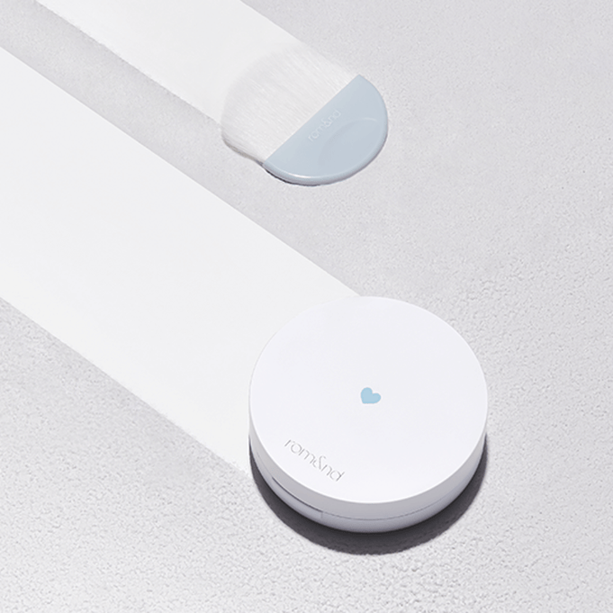 ROMAND Better Than Finish compact and brush on a textured surface