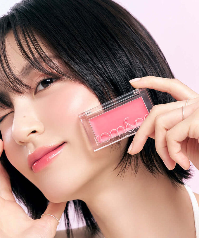Person holding ROMAND better than cheek #glaze, showcasing pink blush.