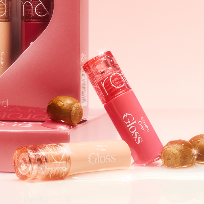 ROMAND MINI Glasting Color Gloss tubes and packaging with a shiny finish over a pink background