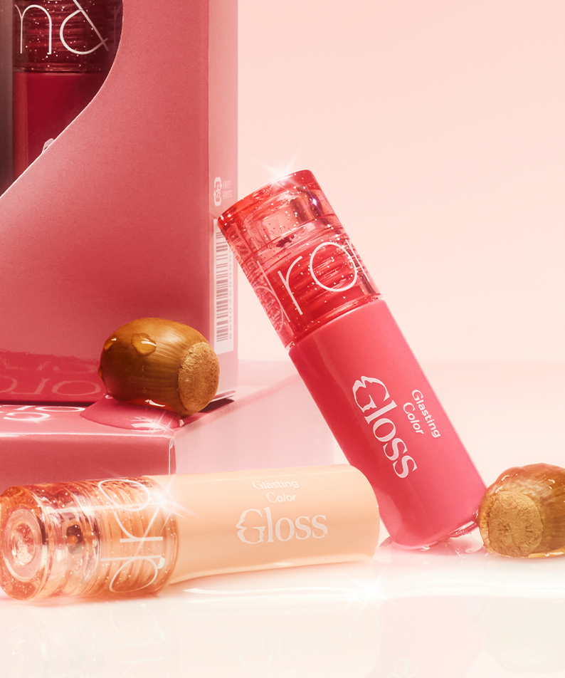 ROMAND MINI Glasting Color Gloss tubes and packaging with a shiny finish over a pink background