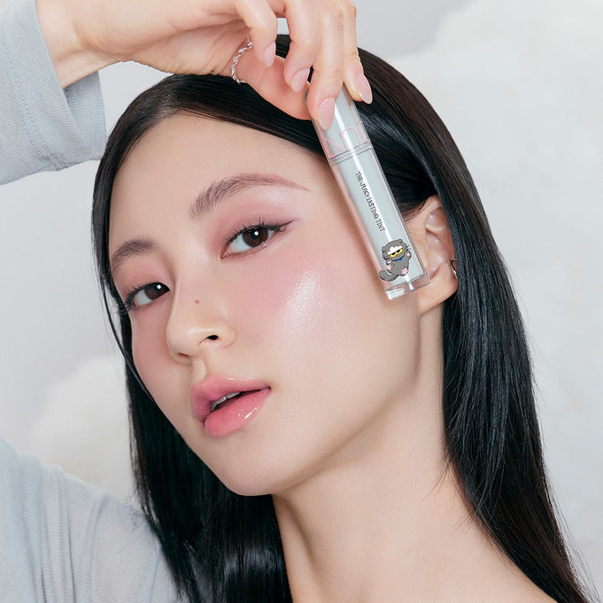 Woman holding ROMAND x Joanne Friends The Juicy Lasting Tint, showcasing vibrant lip tint color.