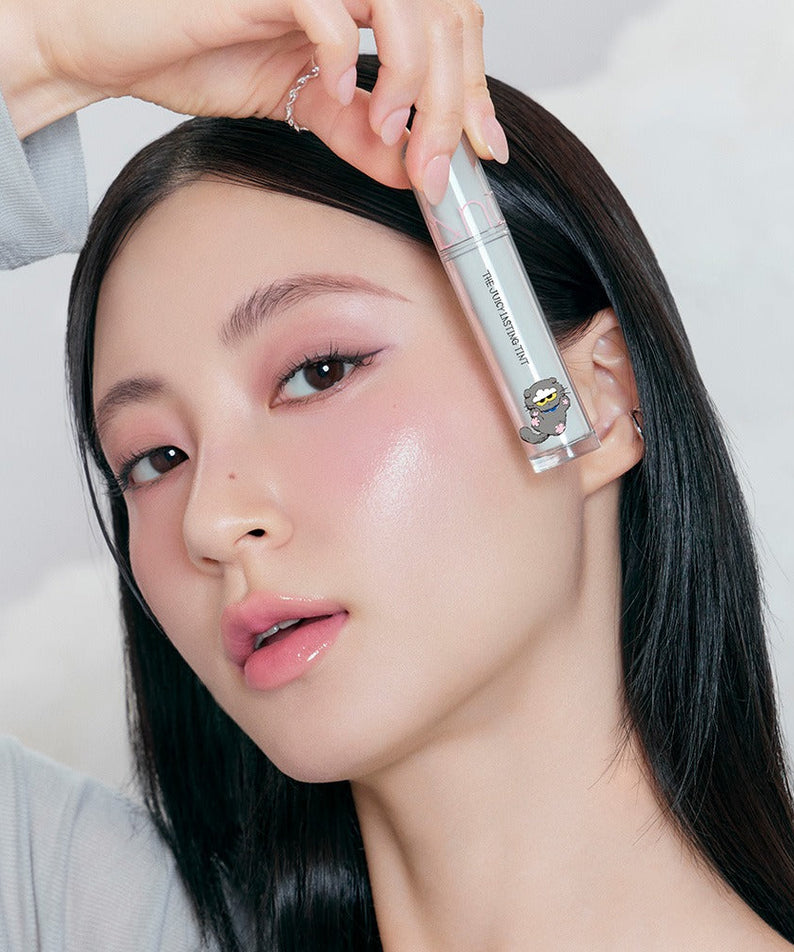 Woman holding ROMAND x Joanne Friends The Juicy Lasting Tint, showcasing vibrant lip tint color.