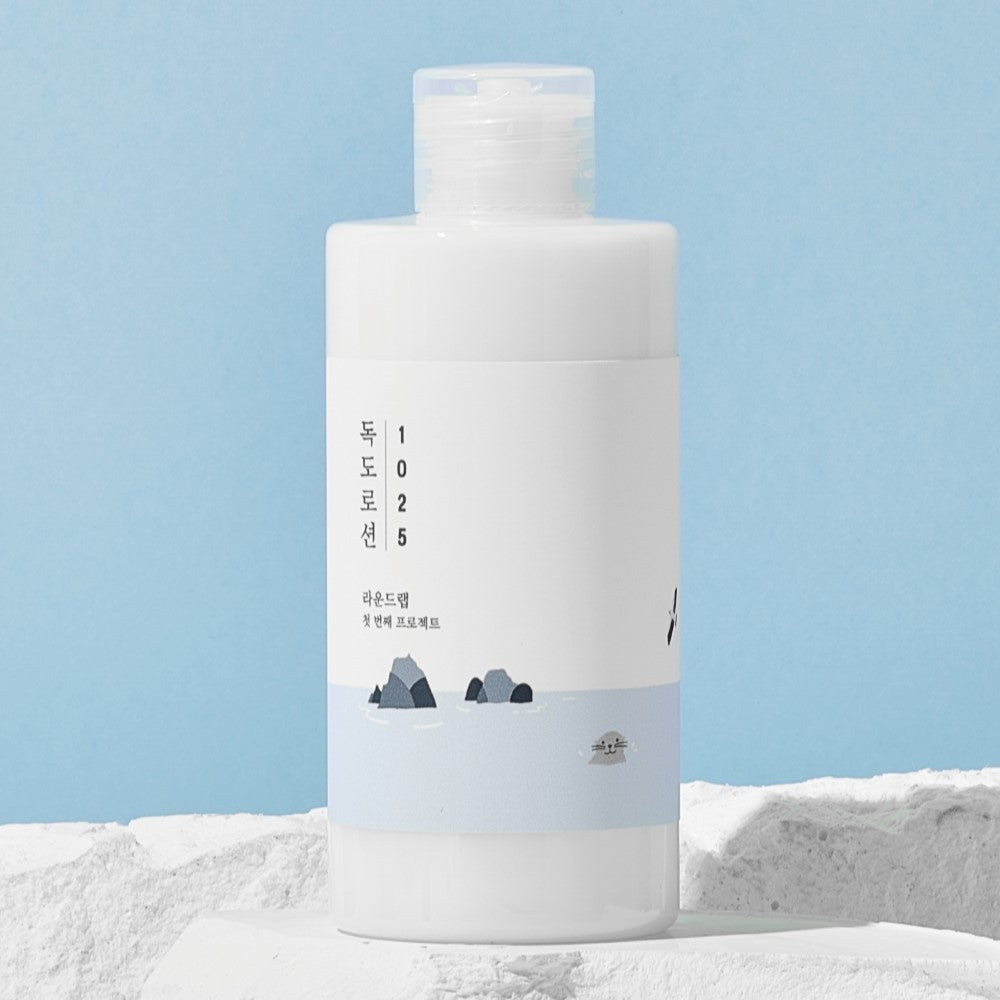 Image of ROUND LAB 1025 Dokdo Lotion 200ml with a minimalistic design and blue accents against a textured background.