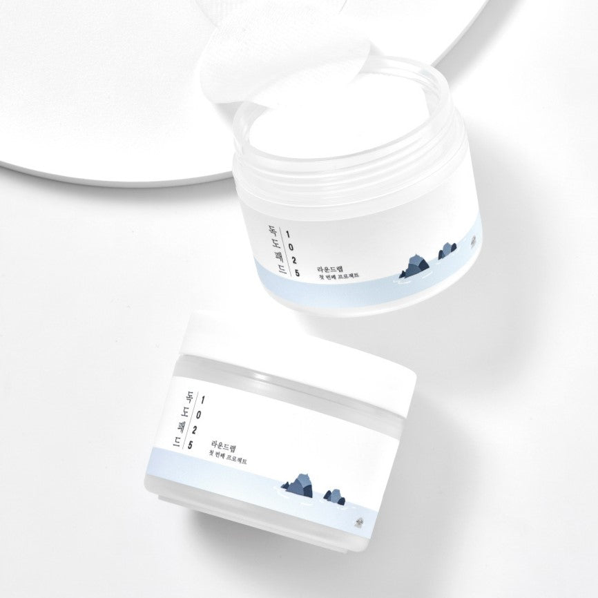 ROUND LAB 1025 Dokdo Pad 70p 120ml in white packaging on a white background, open jar with pads exposed.