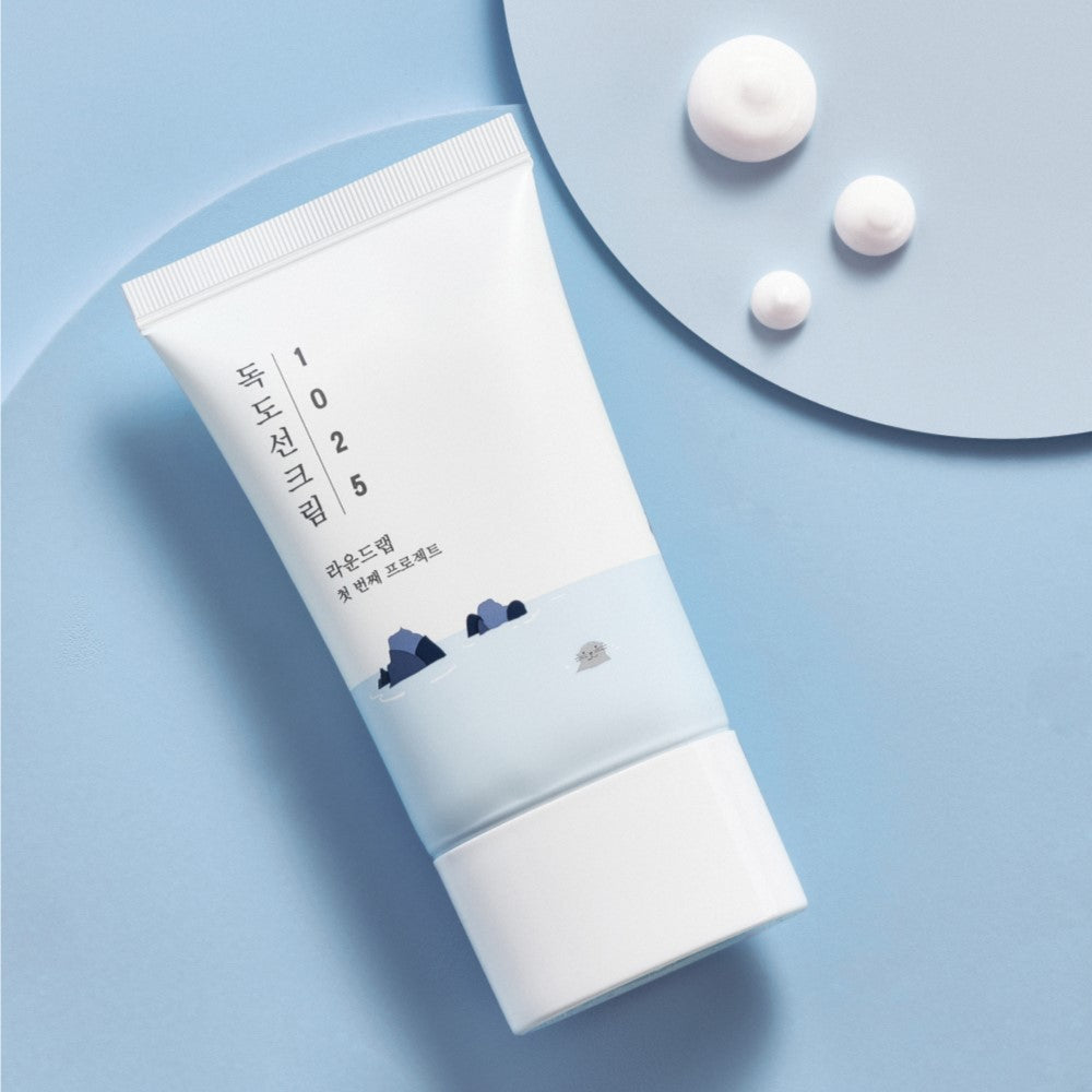 ROUND LAB 1025 Dokdo Sun Cream 50ml tube displayed on a pastel blue background