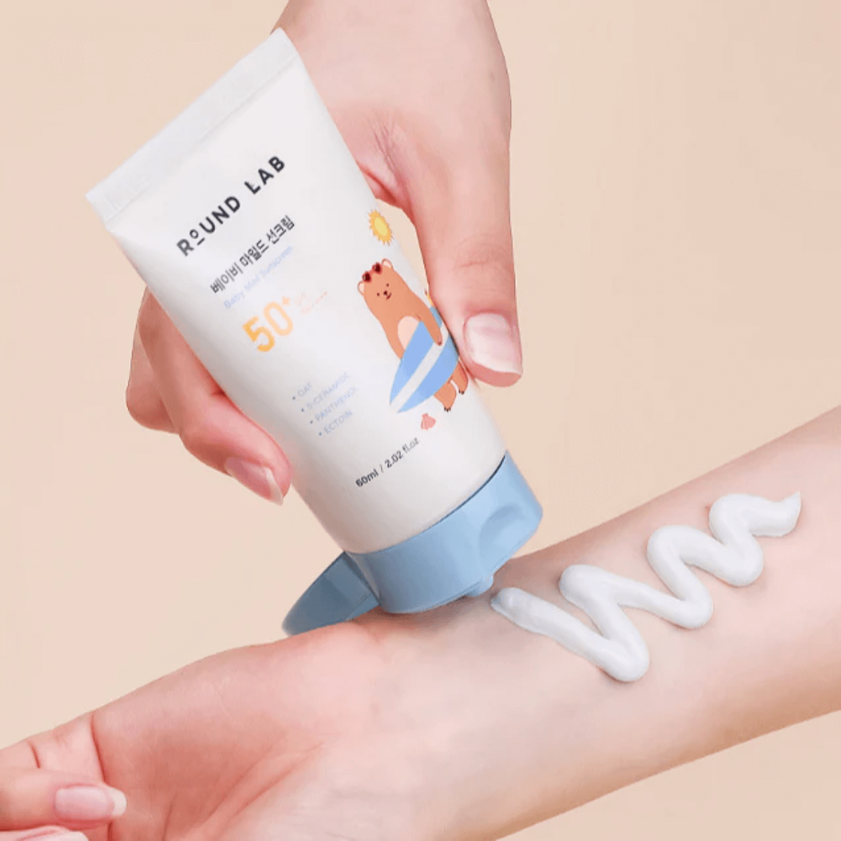 Applying ROUND LAB Baby Mild Sun Cream 60ml on skin, showing creamy texture.