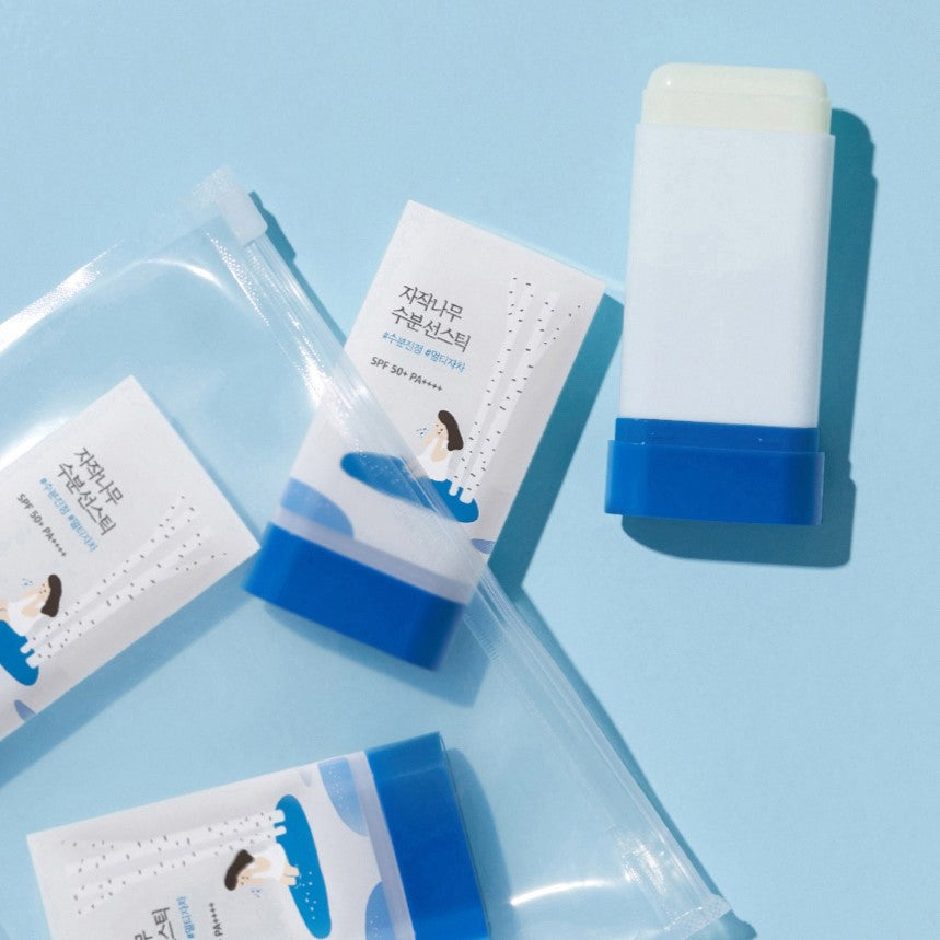 ROUND LAB Birch Juice Moisturizing Sun Stick 19g on a blue background with packaging.