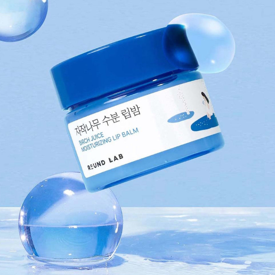 Image of ROUND LAB Birch Moisture Lip Balm 20g in blue packaging against a blue background.
