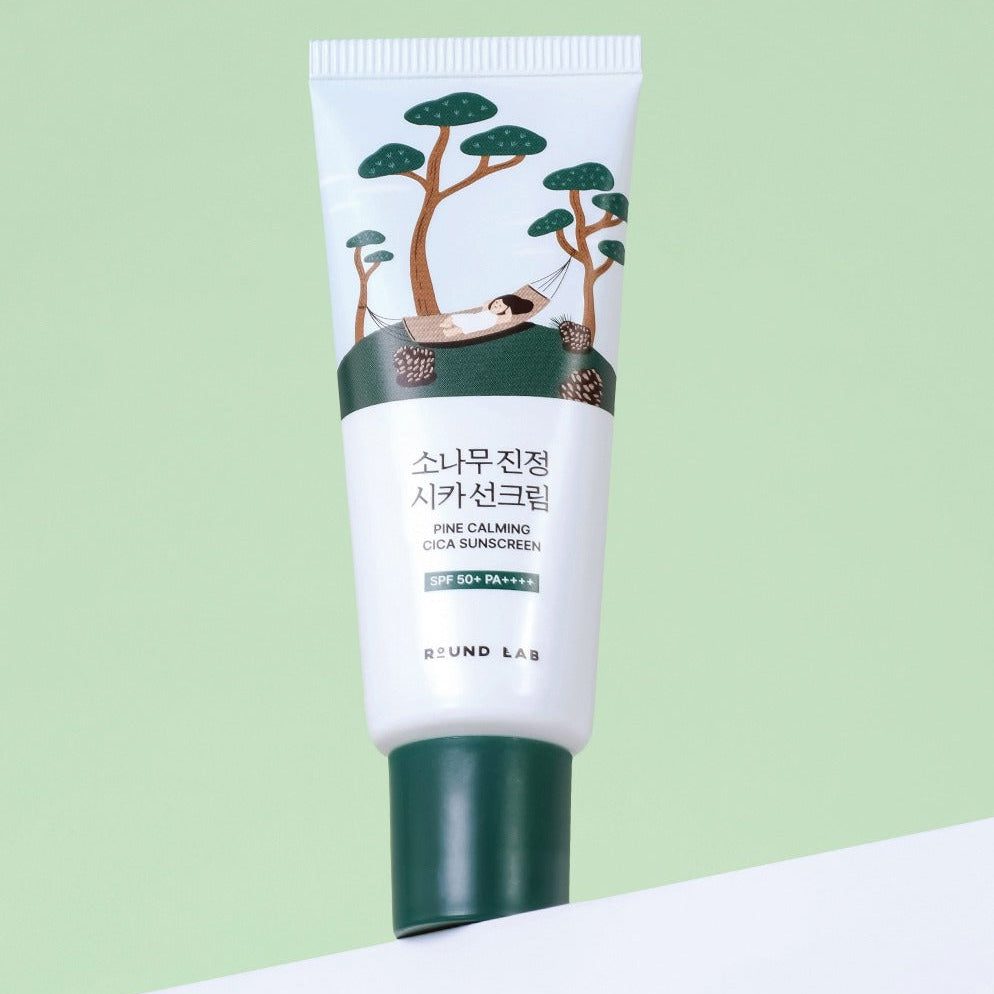 Image of ROUND LAB Pine Calming Cica Sunscreen 40ml tube with illustrated pine trees, promoting SPF 50+ protection.