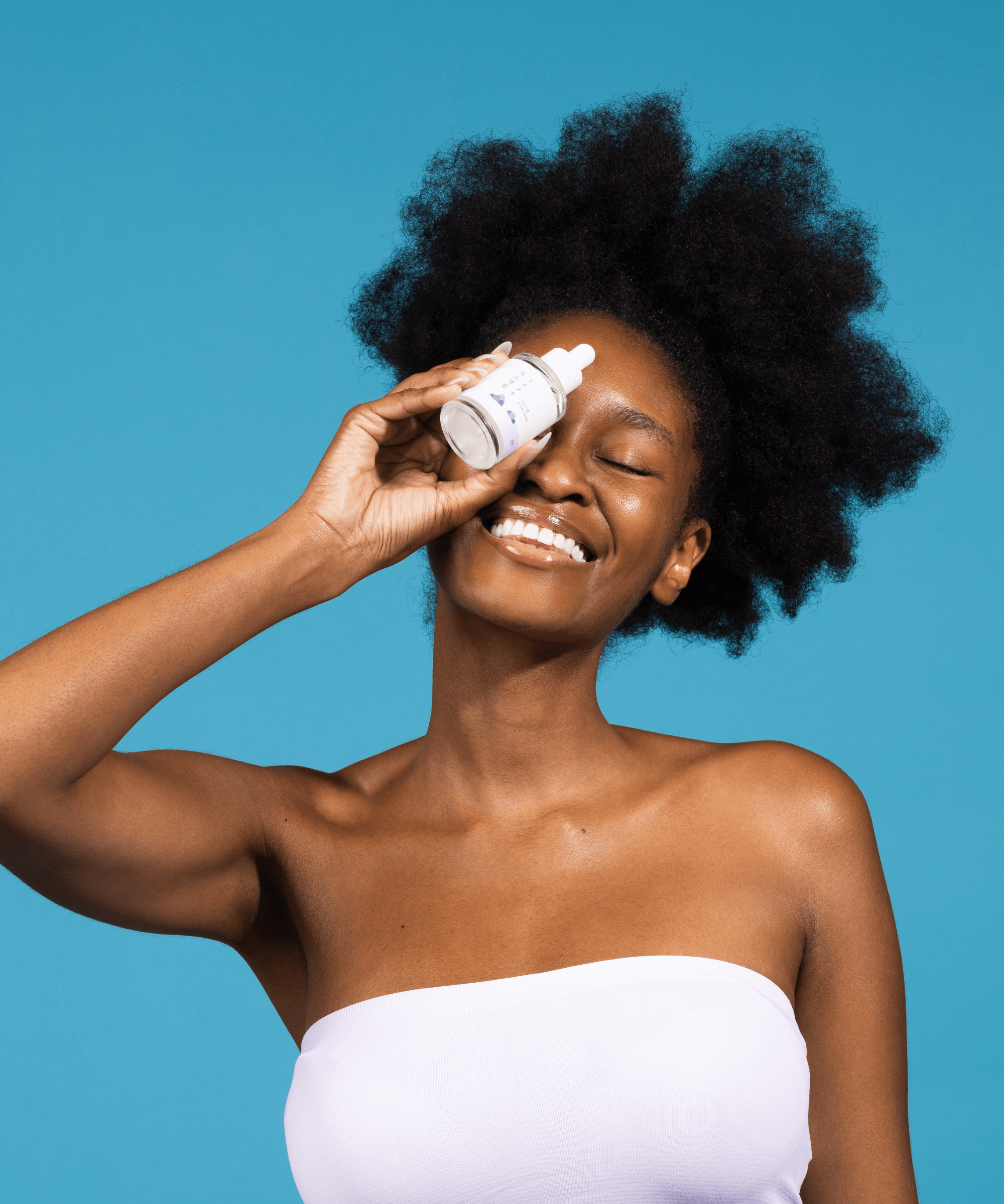 Person holding ROUND LAB 1025 Dokdo Ampoule 45g in front of a blue background, showcasing skincare product