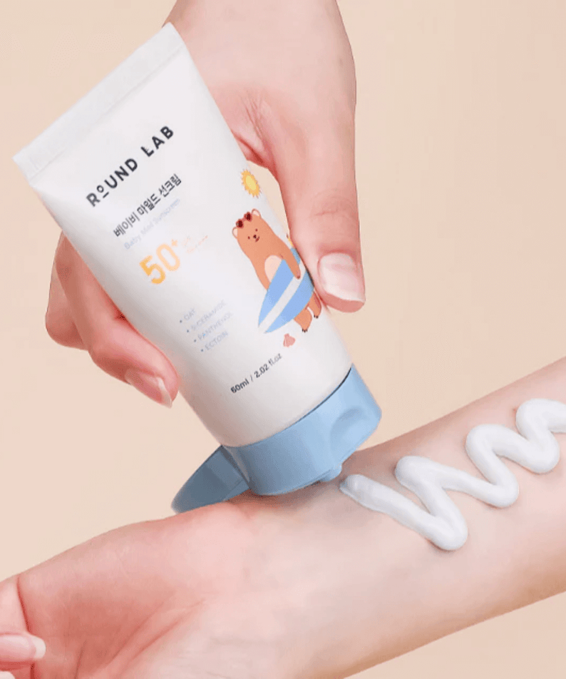 Applying ROUND LAB Baby Mild Sun Cream 60ml on skin, showing creamy texture.