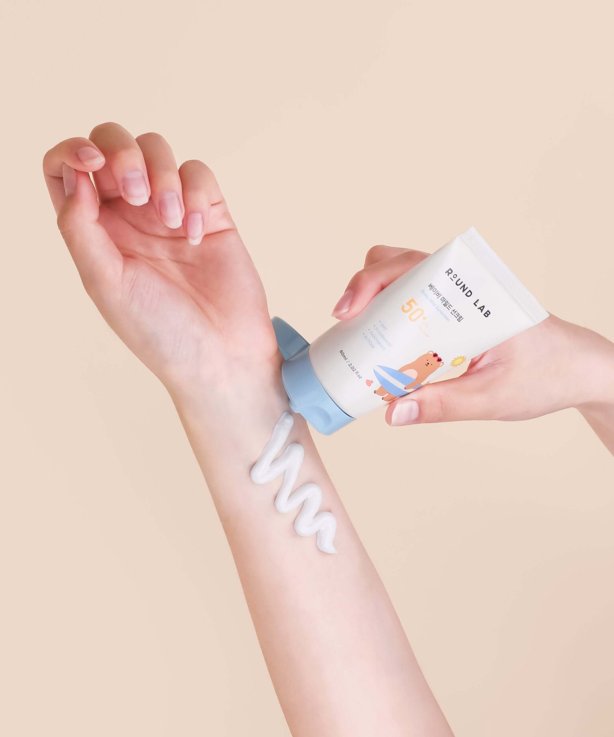 Applying ROUND LAB Baby Mild Sun Cream 60ml to arm for gentle sun protection.