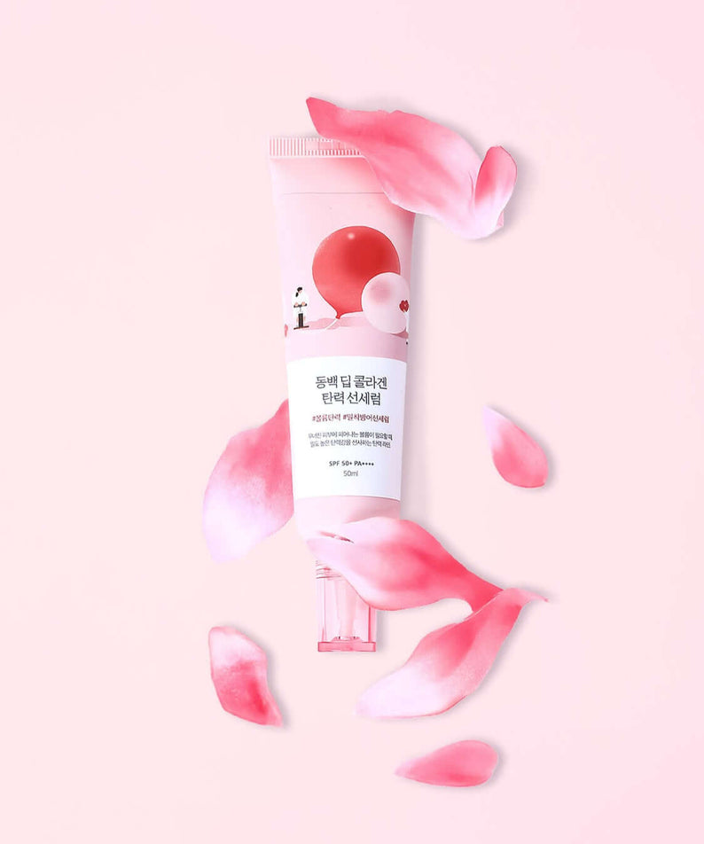 ROUND LAB Dongbaek Deep Collagen Elasticity Sun Serum 50ml surrounded by pink petals on a pastel background
