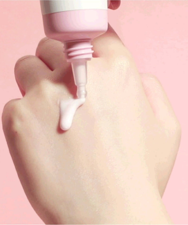 ROUND LAB Dongbaek Deep Collagen Elasticity Sun Serum 50ml being dispensed onto hand for skin care routine.