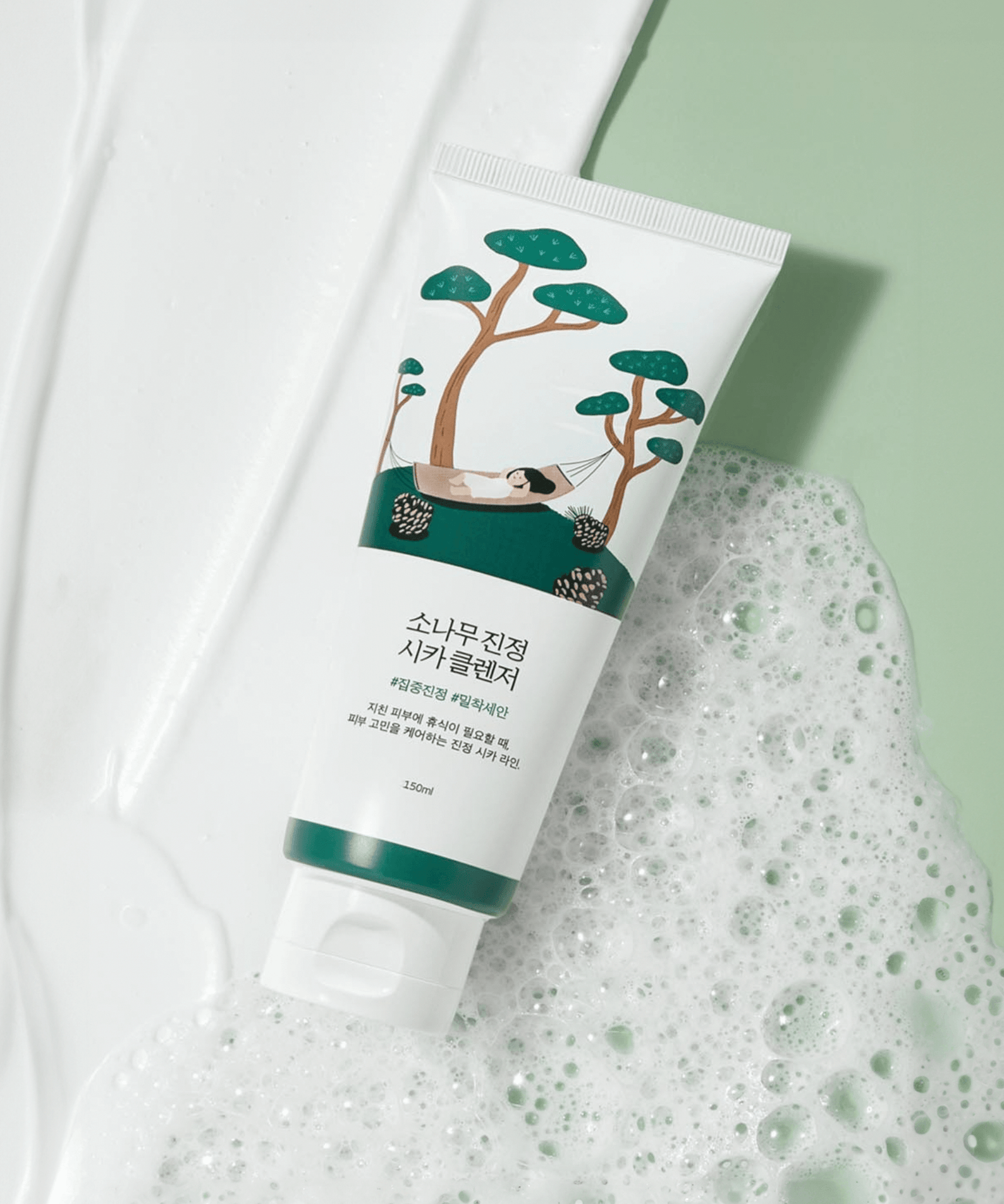 Image of ROUND LAB Pine Calming Cica Cleanser 150ml with soothing pine tree design on a green and white textured background.