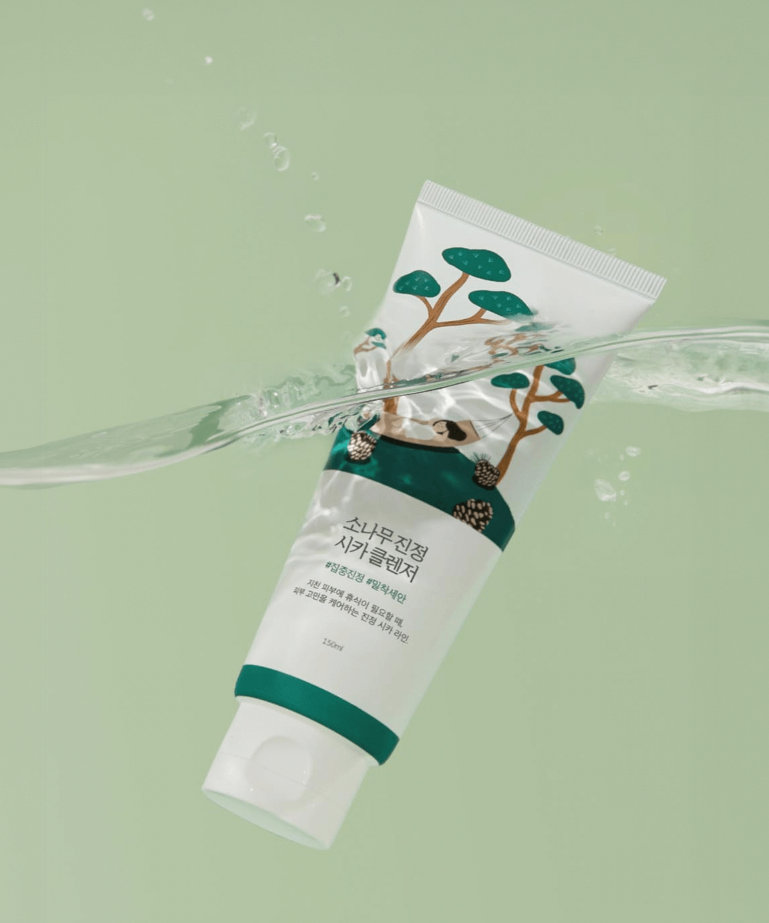 Bottle of ROUND LAB Pine Calming Cica Cleanser 150ml with water backdrop, highlighting soothing skincare properties.