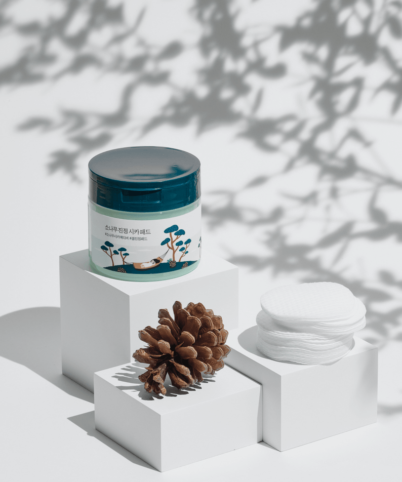 ROUND LAB Pine Calming Cica Pads 50 sheets displayed with pine cone on white blocks for soothing skincare
