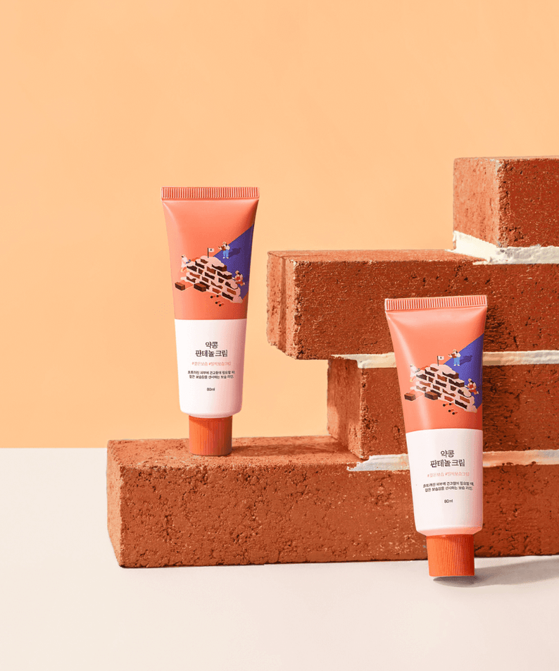 ROUND LAB Yakkong Panthenol Cream 80ml displayed with decorative brick background.