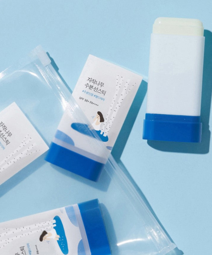 ROUND LAB Birch Juice Moisturizing Sun Stick 19g on a blue background with packaging.