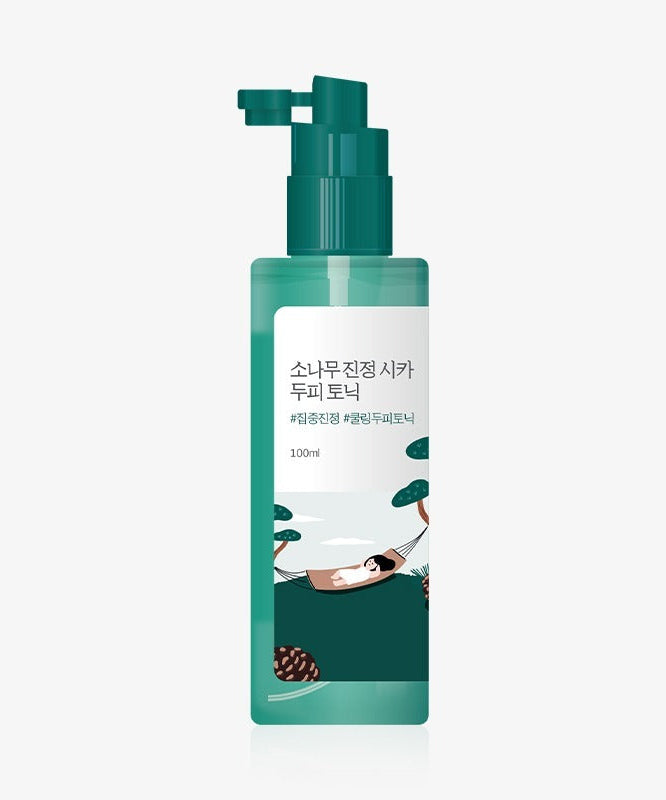 Bottle of ROUND LAB Pine Calming Cica Hair Tonic 100ml with green pump dispenser.