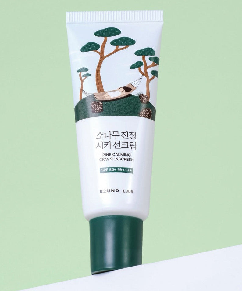 Image of ROUND LAB Pine Calming Cica Sunscreen 40ml tube with illustrated pine trees, promoting SPF 50+ protection.
