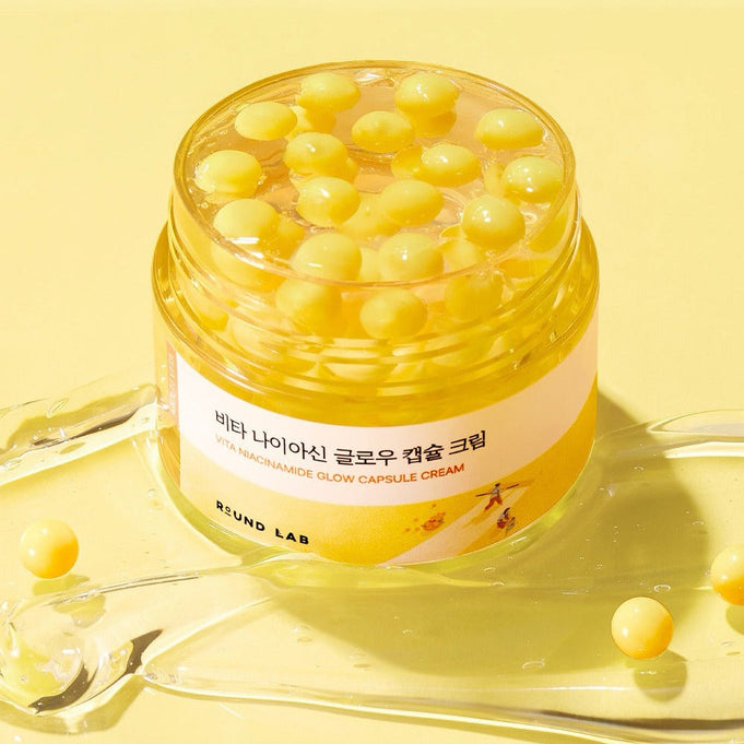 ROUND LAB Vita Niacin Glow Capsule Cream 50ml on yellow background with capsule details.
